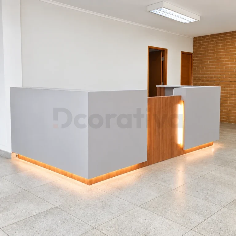 Mesón de recepción blanco y madera con iluminación en el zócalo